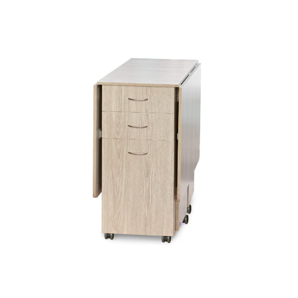 Cutting Table in Grey Oak from Tailormade Sewing Furniture shown in closed position - available at Sewing Center. Cutting Table features an expansive cutting worksurface, front and back storage, and efficient gatelegs. Now with hassle-free home delivery.